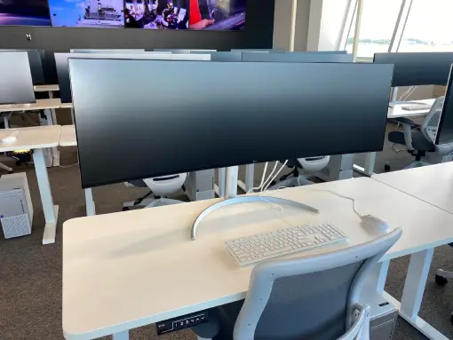 a computer desk with a keyboard and a large monitor